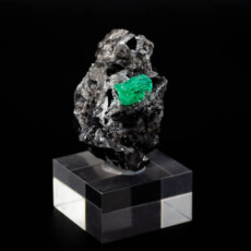 rock with raw emerald crystal with black background
